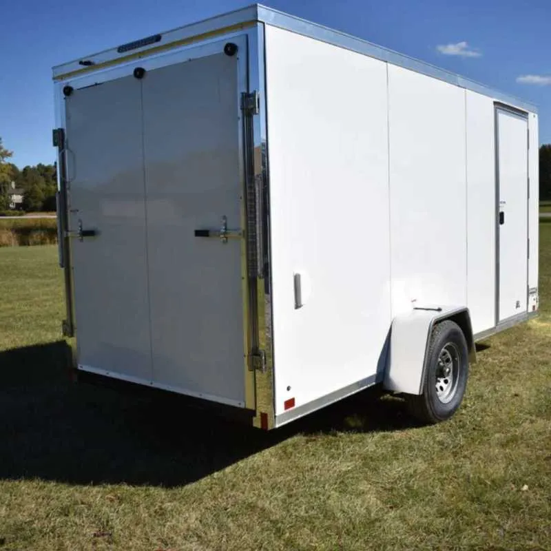 Black 6x14 enclosed cargo trailer with side door parked at factory lot