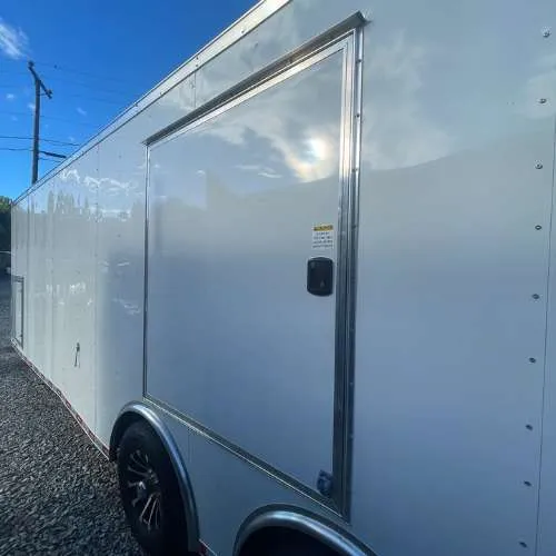 Enclosed car trailer with ramp door lowered for vehicle loading